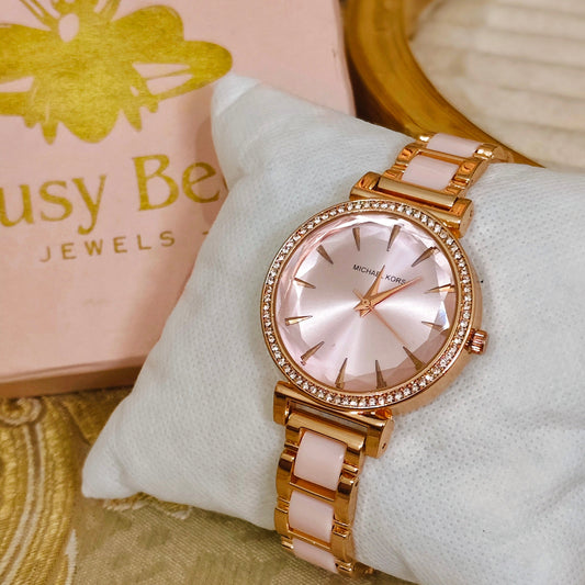Rose gold watch on a white cushion with 'Busy Bee Jewels' box in the background